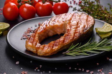 Taze pişirilmiş lezzetli somon bifteği, baharatlar ve ızgarada pişirilmiş otlar. Sağlıklı deniz ürünleri