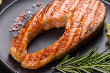 Taze pişirilmiş lezzetli somon bifteği, baharatlar ve ızgarada pişirilmiş otlar. Sağlıklı deniz ürünleri