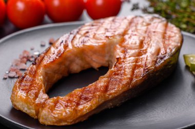 Taze pişirilmiş lezzetli somon bifteği, baharatlar ve ızgarada pişirilmiş otlar. Sağlıklı deniz ürünleri