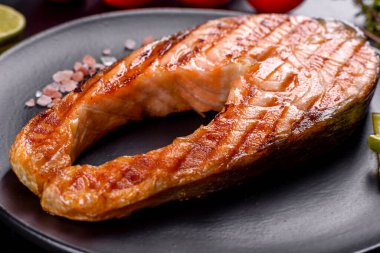 Taze pişirilmiş lezzetli somon bifteği, baharatlar ve ızgarada pişirilmiş otlar. Sağlıklı deniz ürünleri