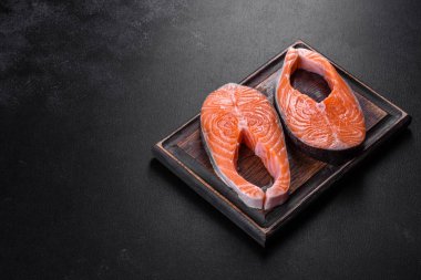 Izgara pişirme için baharatlı ve otlu taze çiğ somon bifteği. Sağlıklı deniz ürünleri