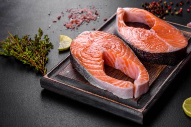 Izgara pişirme için baharatlı ve otlu taze çiğ somon bifteği. Sağlıklı deniz ürünleri