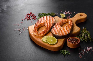 Taze pişirilmiş lezzetli somon bifteği, baharatlar ve ızgarada pişirilmiş otlar. Sağlıklı deniz ürünleri