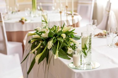 Düğün bayramının güzel süslemeleri, çiçeklerle süslenmiş yeşillikler. Evlilik töreni için hazırlıklar.