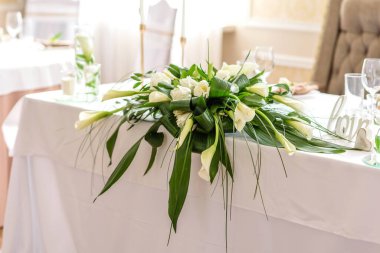 Düğün bayramının güzel süslemeleri, çiçeklerle süslenmiş yeşillikler. Evlilik töreni için hazırlıklar.