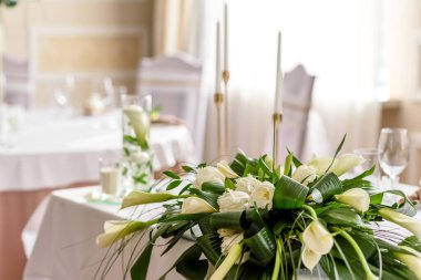 Düğün bayramının güzel süslemeleri, çiçeklerle süslenmiş yeşillikler. Evlilik töreni için hazırlıklar.