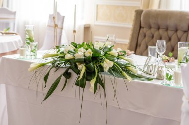 Düğün bayramının güzel süslemeleri, çiçeklerle süslenmiş yeşillikler. Evlilik töreni için hazırlıklar.