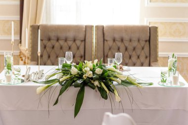 Düğün bayramının güzel süslemeleri, çiçeklerle süslenmiş yeşillikler. Evlilik töreni için hazırlıklar.