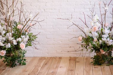 Decorations of branches with beautiful pink and white flowers in the basket against the background of a white brick wall. Home scenery