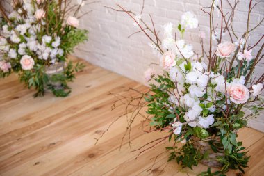 Decorations of branches with beautiful pink and white flowers in the basket against the background of a white brick wall. Home scenery