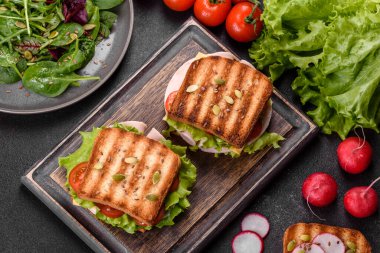 Çıtır tostlu, jambonlu, marullu ve domatesli lezzetli sandviç. Hızlı besleyici kahvaltı.