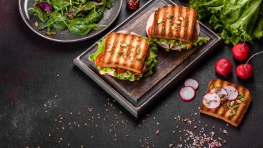 Çıtır tostlu, jambonlu, marullu ve domatesli lezzetli sandviç. Hızlı besleyici kahvaltı.