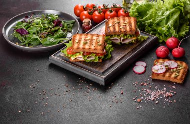 Çıtır tostlu, jambonlu, marullu ve domatesli lezzetli sandviç. Hızlı besleyici kahvaltı.