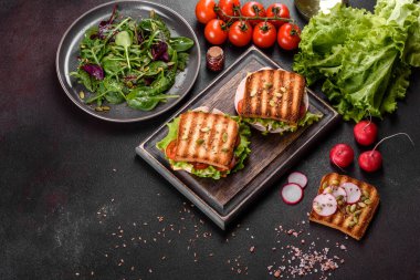 Çıtır tostlu, jambonlu, marullu ve domatesli lezzetli sandviç. Hızlı besleyici kahvaltı.