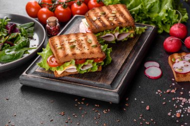 Çıtır tostlu, jambonlu, marullu ve domatesli lezzetli sandviç. Hızlı besleyici kahvaltı.