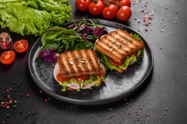 Çıtır tostlu, jambonlu, marullu ve domatesli lezzetli sandviç. Hızlı besleyici kahvaltı.