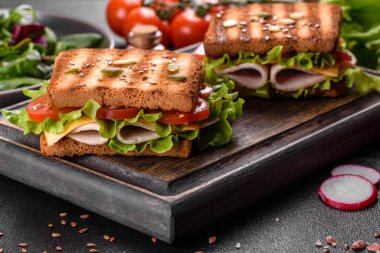 Çıtır tostlu, jambonlu, marullu ve domatesli lezzetli sandviç. Hızlı besleyici kahvaltı.