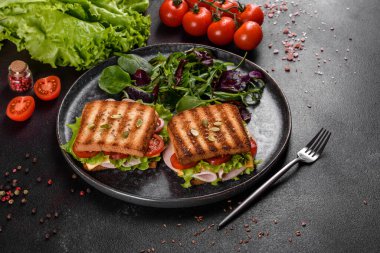 Çıtır tostlu, jambonlu, marullu ve domatesli lezzetli sandviç. Hızlı besleyici kahvaltı.