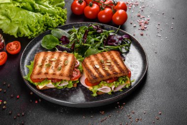 Çıtır tostlu, jambonlu, marullu ve domatesli lezzetli sandviç. Hızlı besleyici kahvaltı.