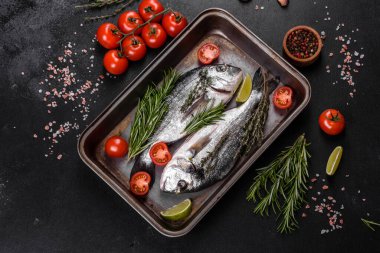 Kesme tahtasında baharatlı çiğ dorado balığı. Taze balık dorado. Dorado ve masada yemek yapmak için malzemeler.