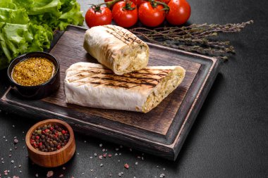 Koyu beton bir masada et ve sebzeli leziz taze shawarma. Fast food, Türk mutfağı
