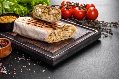 Koyu beton bir masada et ve sebzeli leziz taze shawarma. Fast food, Türk mutfağı