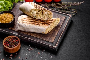 Koyu beton bir masada et ve sebzeli leziz taze shawarma. Fast food, Türk mutfağı
