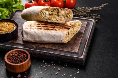 Koyu beton bir masada et ve sebzeli leziz taze shawarma. Fast food, Türk mutfağı