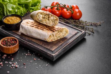 Koyu beton bir masada et ve sebzeli leziz taze shawarma. Fast food, Türk mutfağı