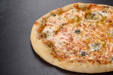 Lezzetli fırında pizza, domatesli, peynirli ve mantarlı koyu beton arka planda. İtalyan mutfağı