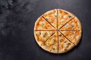 Lezzetli fırında pizza, domatesli, peynirli ve mantarlı koyu beton arka planda. İtalyan mutfağı