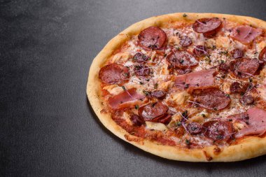 Üzerinde domates, salam ve pastırma olan lezzetli fırın pizzası. İtalyan mutfağı