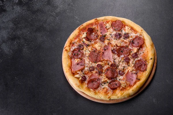 Üzerinde domates, salam ve pastırma olan lezzetli fırın pizzası. İtalyan mutfağı