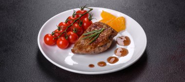 Koyu beton arka planda otlar ve baharatlarla pişirilmiş ördek göğsü. Kızarmış et yemek için hazır.