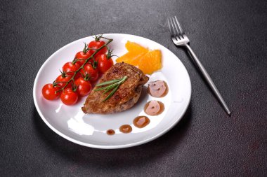 Koyu beton arka planda otlar ve baharatlarla pişirilmiş ördek göğsü. Kızarmış et yemek için hazır.