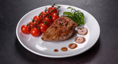 Koyu beton arka planda otlar ve baharatlarla pişirilmiş ördek göğsü. Kızarmış et yemek için hazır.