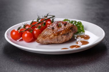 Koyu beton arka planda otlar ve baharatlarla pişirilmiş ördek göğsü. Kızarmış et yemek için hazır.