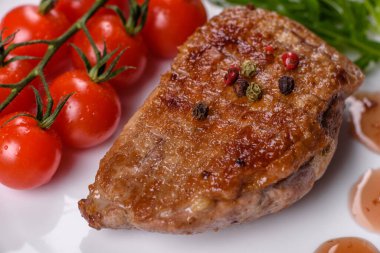 Koyu beton arka planda otlar ve baharatlarla pişirilmiş ördek göğsü. Kızarmış et yemek için hazır.