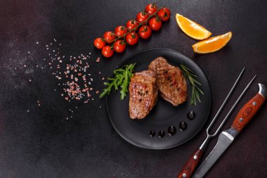 Koyu beton arka planda otlar ve baharatlarla pişirilmiş ördek göğsü. Kızarmış et yemek için hazır.