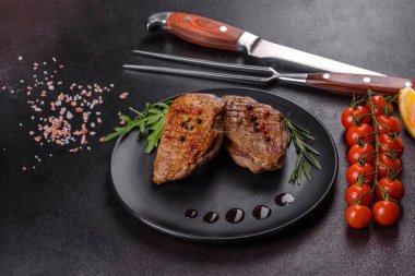 Koyu beton arka planda otlar ve baharatlarla pişirilmiş ördek göğsü. Kızarmış et yemek için hazır.