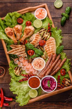 Izgarada hazırlanmış sosis, tavuk, domuz ve karidesin yanı sıra baharat ve otlarla ızgarada hazırlanmış sebzeler. Alevler içinde yemek yapmak