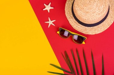 Plaj aksesuarları: kabuklu gözlük ve şapka ve renkli arka planda deniz yıldızları. Yaz arkaplanı