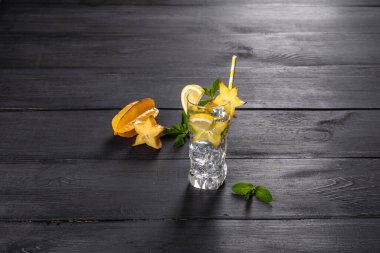 Limonata, nane şekeri ve buz küpleri gri taştan arka planda.