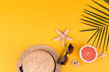 Plaj aksesuarları: kabuklu gözlük ve şapka ve renkli arka planda deniz yıldızları. Yaz arkaplanı