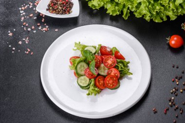 Sebzeli taze salata: domates, salatalık, soğan ve zeytinyağlı yeşillikler. Yaz menüsü salataları