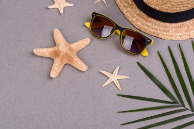 Kabuklu plaj aksesuarları ve renkli arka planda deniz yıldızları.