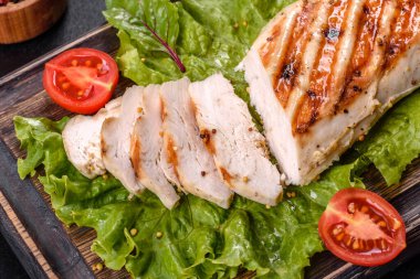 Koyu beton arka planda tavuk, domates ve marul parçaları. Lezzetli sağlıklı yemek.