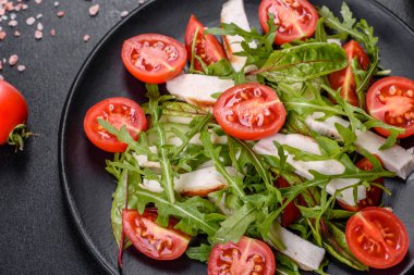 Koyu beton arka planda tavuk, domates ve marul parçaları. Lezzetli sağlıklı yemek.