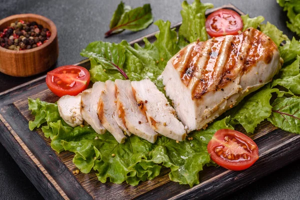 Koyu beton arka planda tavuk, domates ve marul parçaları. Lezzetli sağlıklı yemek.