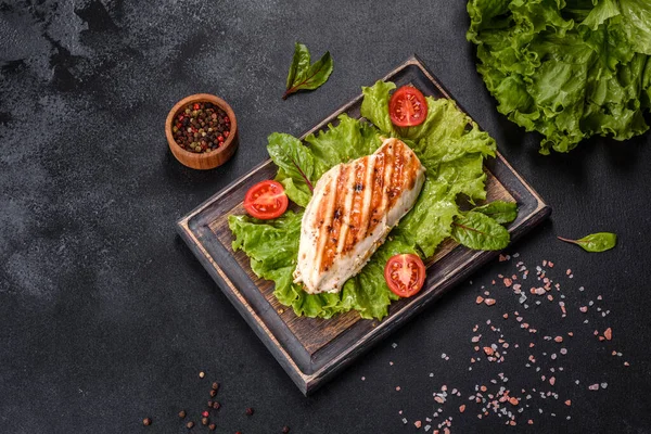 Koyu beton arka planda tavuk, domates ve marul parçaları. Lezzetli sağlıklı yemek.